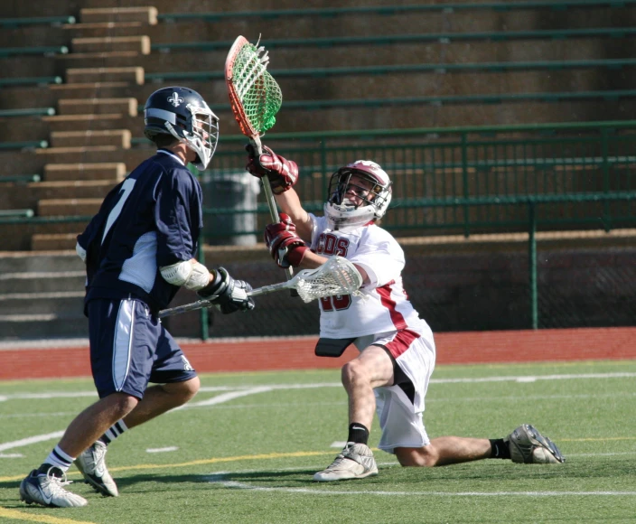 a man holding onto the lacrosse ball while a lacrosse player tries to block him