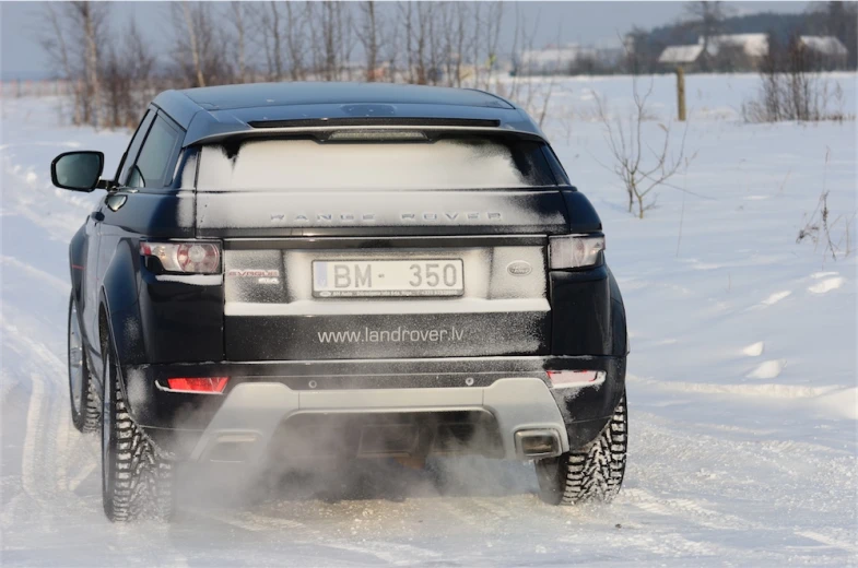 a black jeep is in the middle of a snow covered road