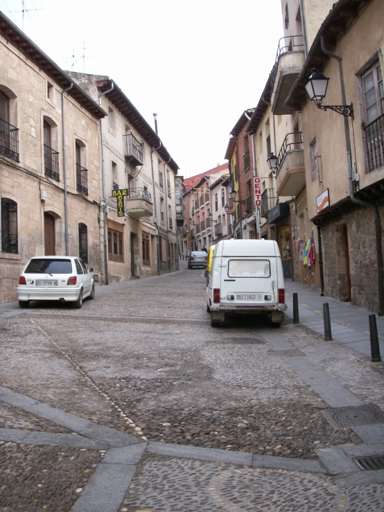 some vehicles parked on the side of an empty street