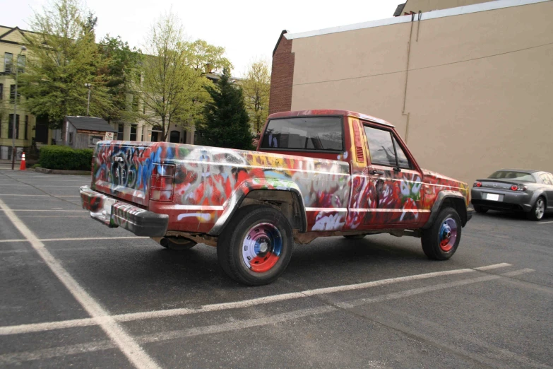 an old pickup truck with paint on it parked in a parking lot