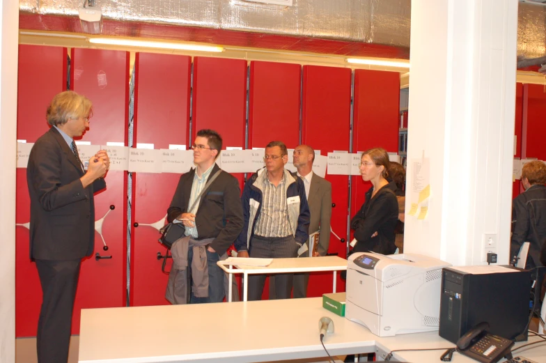 several business people stand in front of a wall