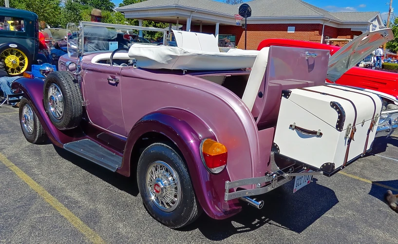 an old model car parked with its hood up