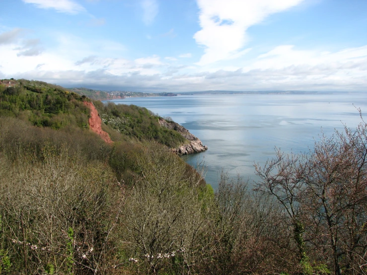 the view of a mountain and an ocean from a hill