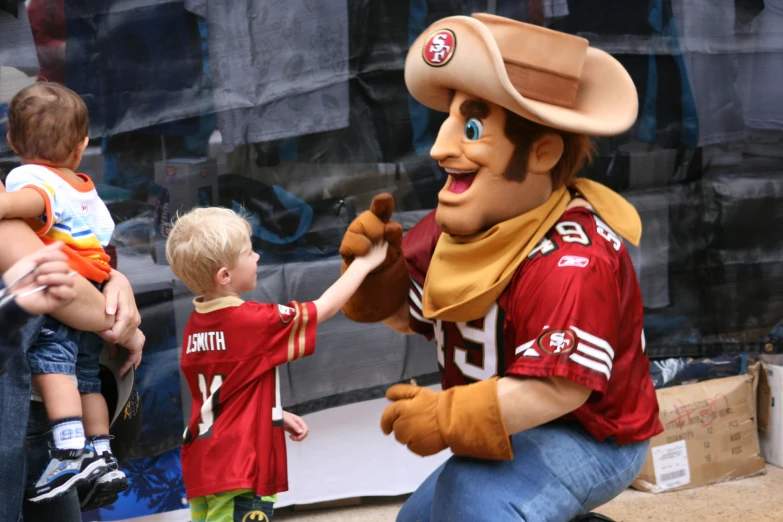 a man wearing a cowboy costume holding a toddler