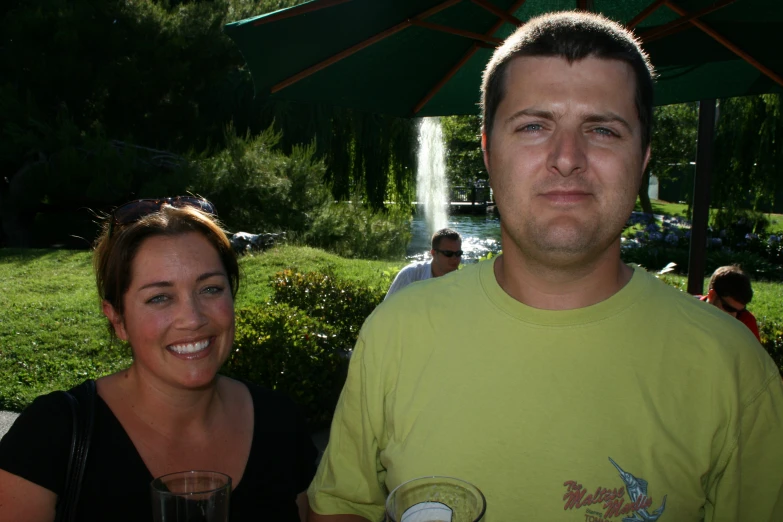 man and woman posing for a po underneath an umbrella