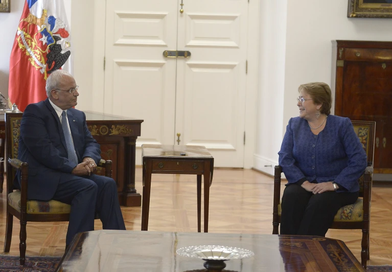 two people sit near one another in chairs