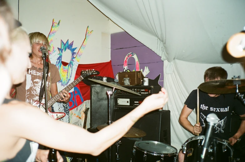 several people are playing instruments in a tent