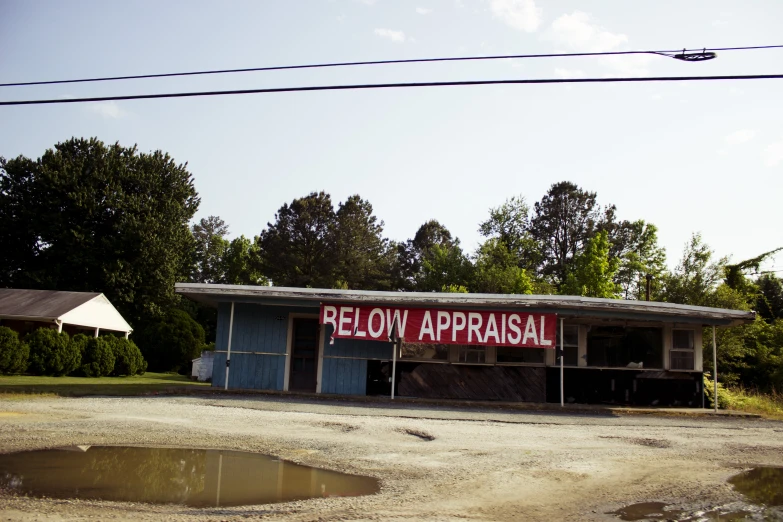 a run down building with a sign that reads below