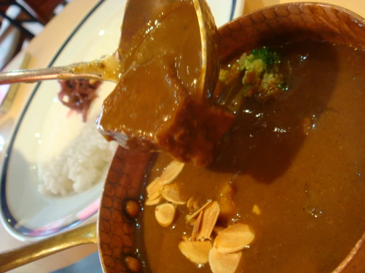 a brown bowl filled with broth and different types of food