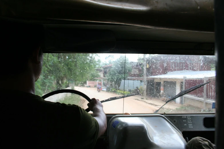 a man holding the steering wheel of a bus