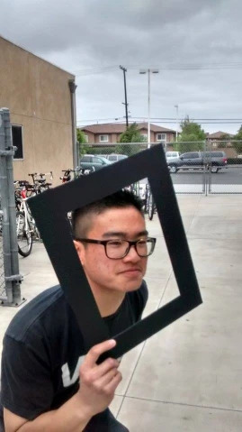 a man poses with an image of himself outside