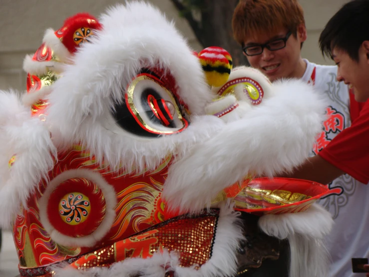 a man holds a white and red dragon statue