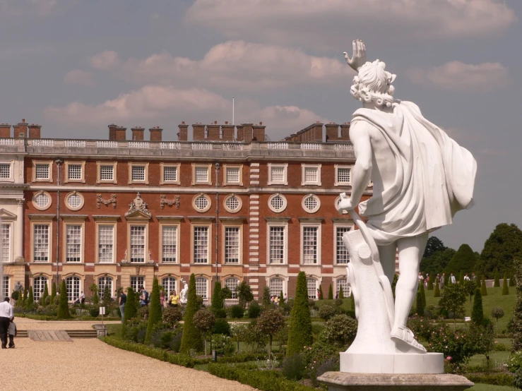 a large building with two pillars with statues in front of it