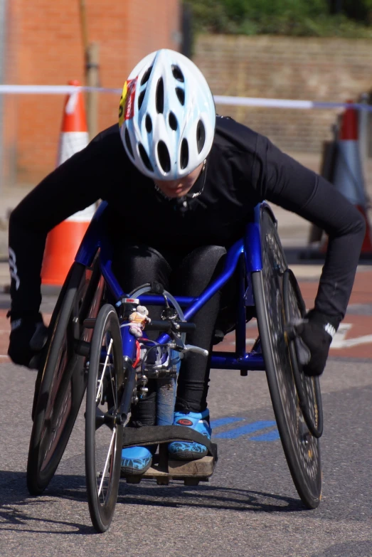 a man in a wheel chair with his legs bent over his knees