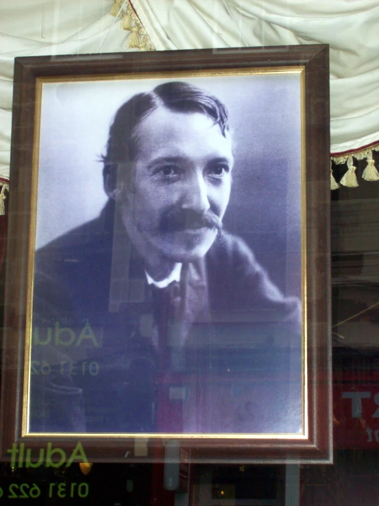 a portrait is hung on a glass window