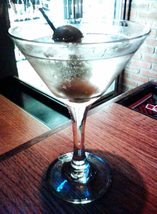 a drink is in a martini glass sitting on a table