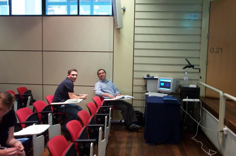 two men sitting in front of some microphones and chairs