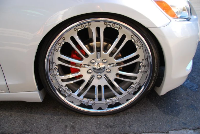 a silver car with white accents sits parked on the sidewalk