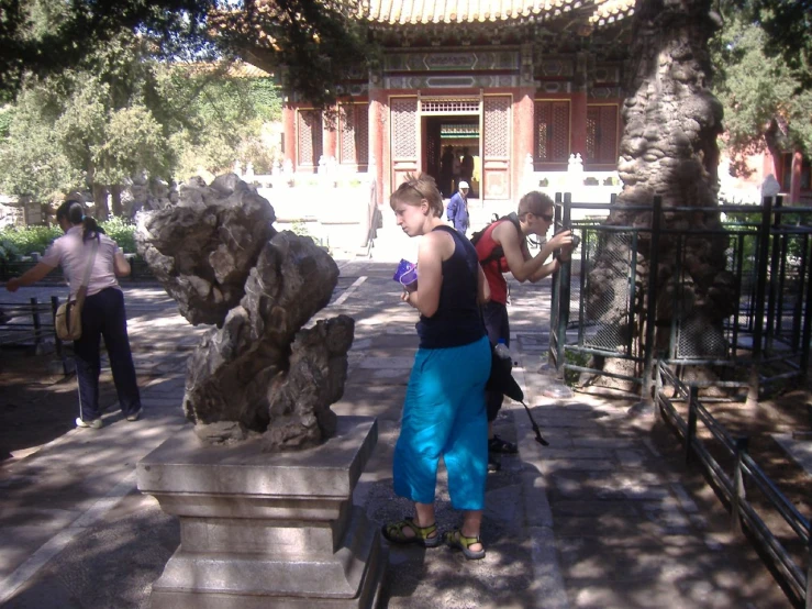 a woman standing near stone structures in a courtyard