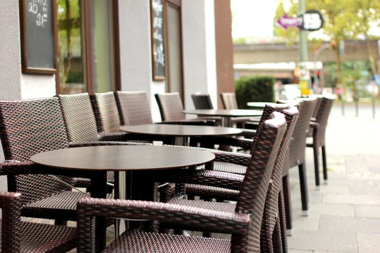 a restaurant with chairs, tables and a chalkboard sign