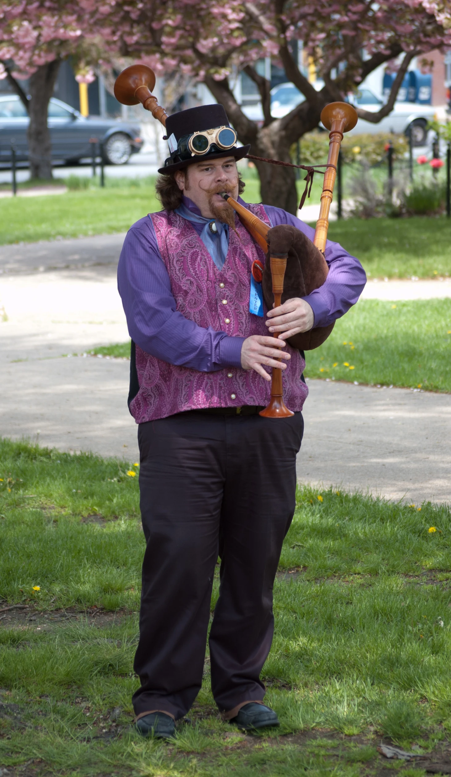 a man with a pipe in front of trees and green grass