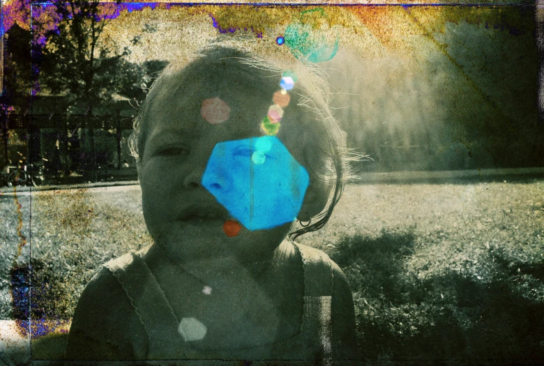 a woman in the middle of a field has her face up with a kite shaped piece over her head