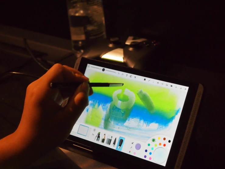 someone holding a brush drawing soing on a tablet