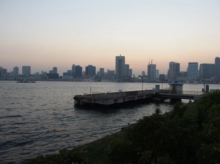 a pier in the water near a city skyline