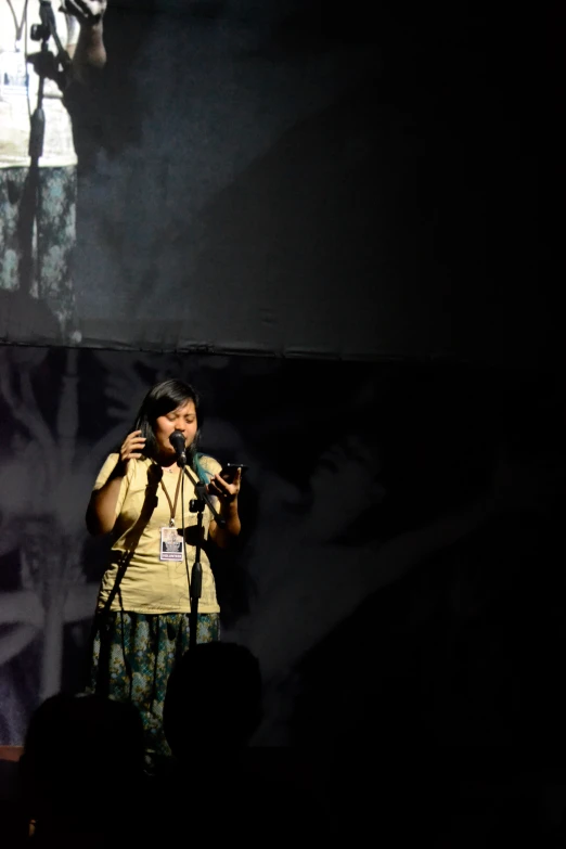 a woman in yellow shirt and green pants on stage