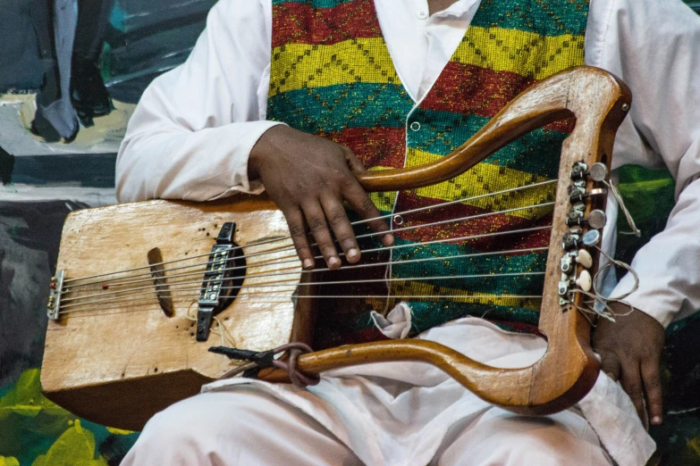 a man playing an instrument with a large wooden body