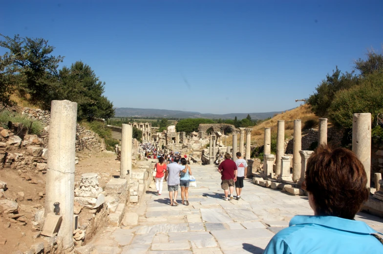 a group of people walking in a roman ruins