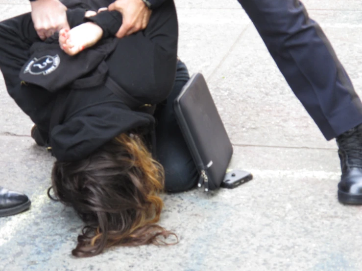 a man sits on the ground near a woman in black