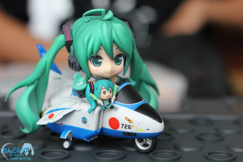 a close up of a tiny doll sitting on a model airplane