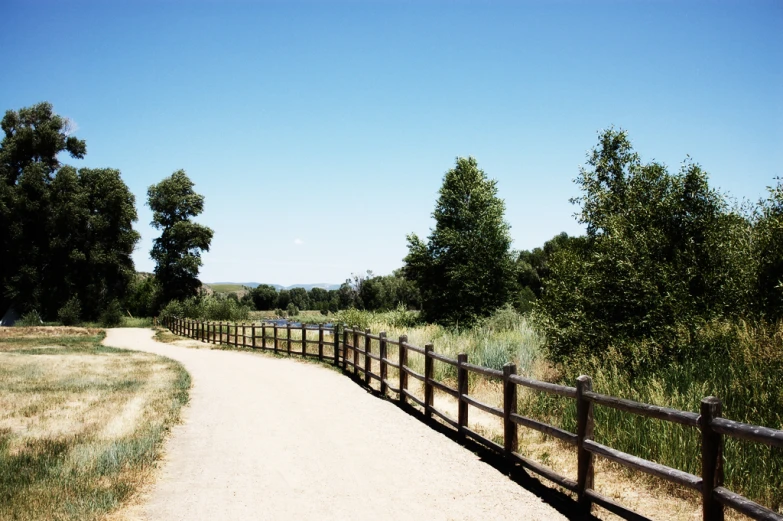 a brown wooden fence and some dirt and grass