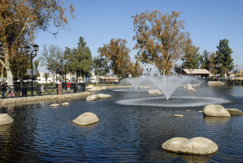 a pond that has rocks in it and the water splashing off