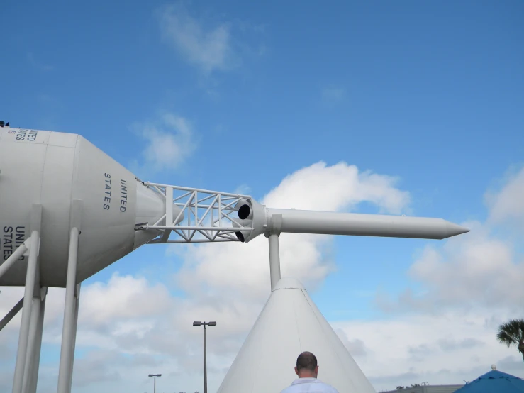 a man looks at the air traffic control tower in front of the propeller airplane