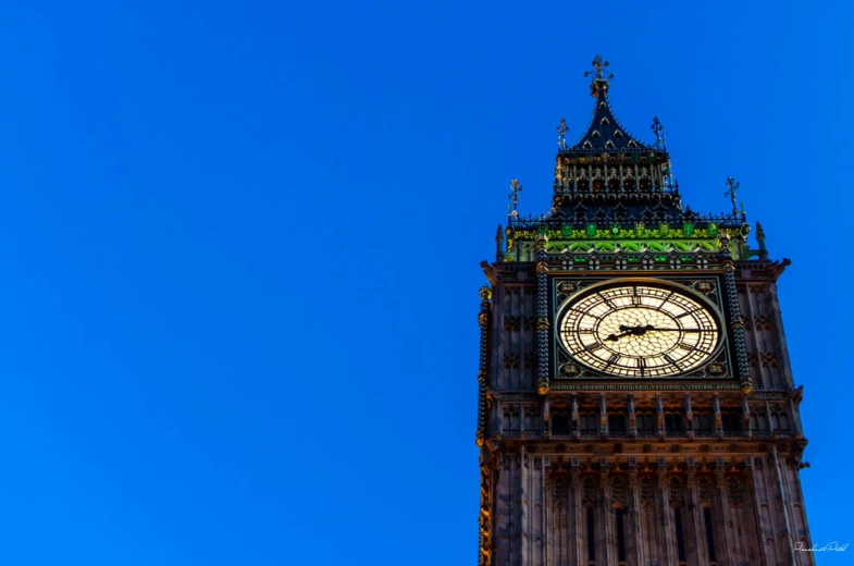 the big ben clock tower lit up in the day light