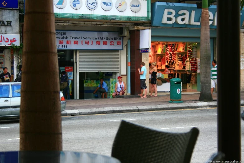 street scene with people standing near shops on city street