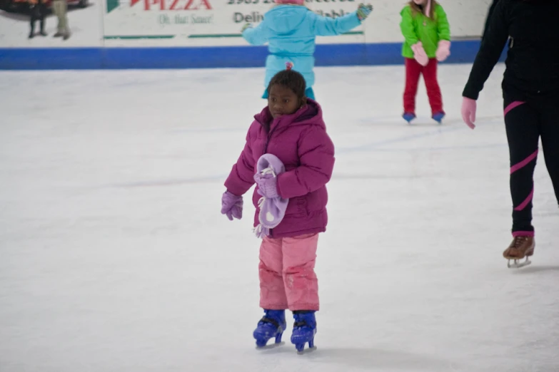 a little girl skates on an ice rink