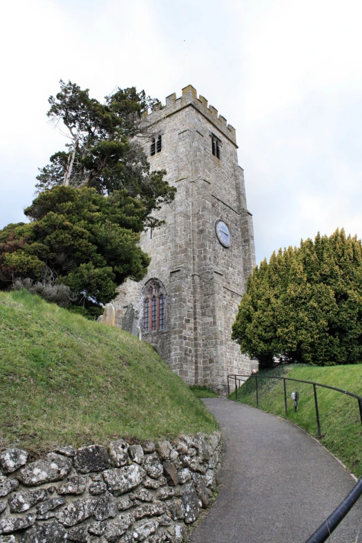 a path that runs to a large castle with a clock on the side