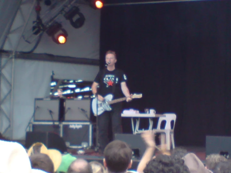 a man holding an electric guitar in his hand at a concert