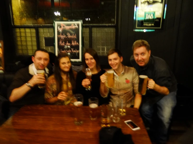 there are five people enjoying drinks at the table