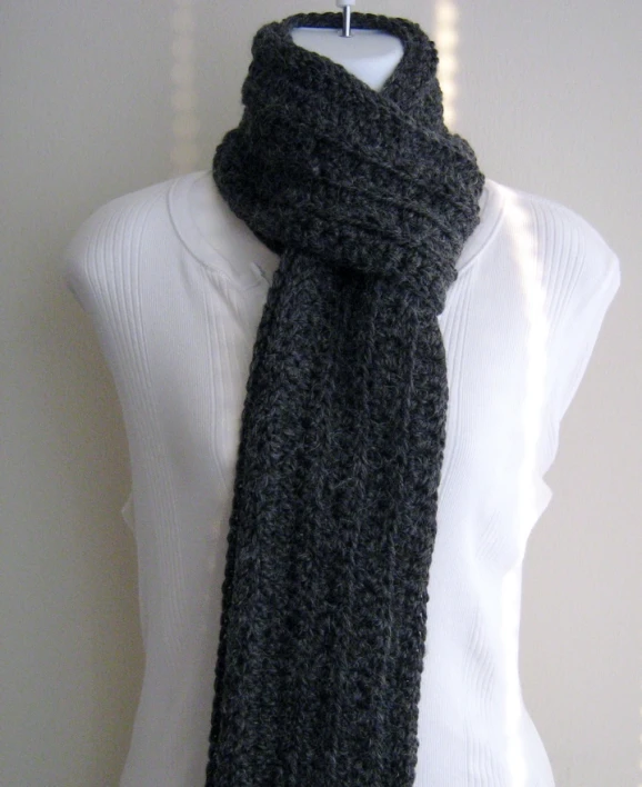 a black knit scarf sitting on top of a mannequin's torso