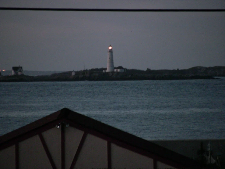 a white lighthouse at the end of the ocean