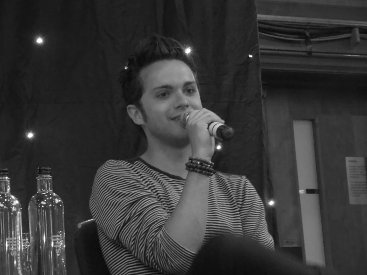 a person that is sitting down in front of a microphone