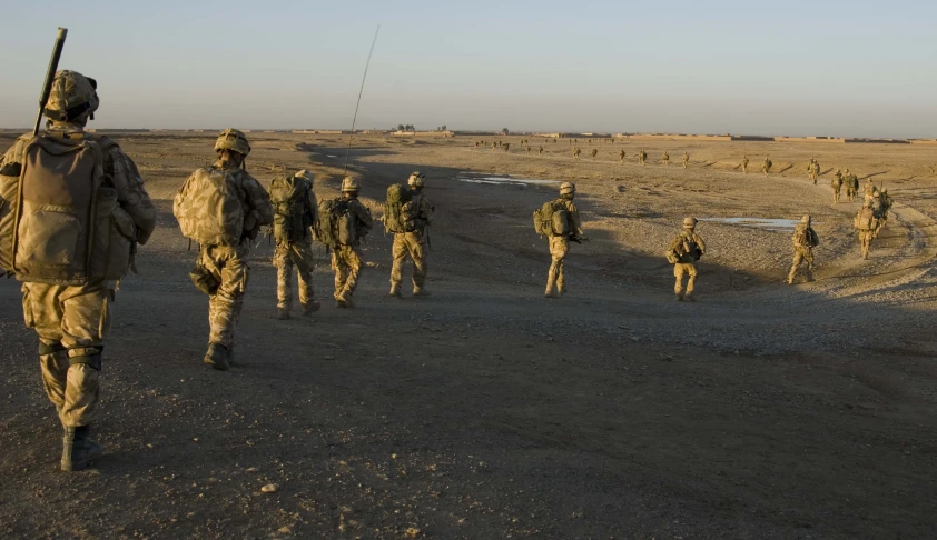 a group of soldiers marching along a dirt road