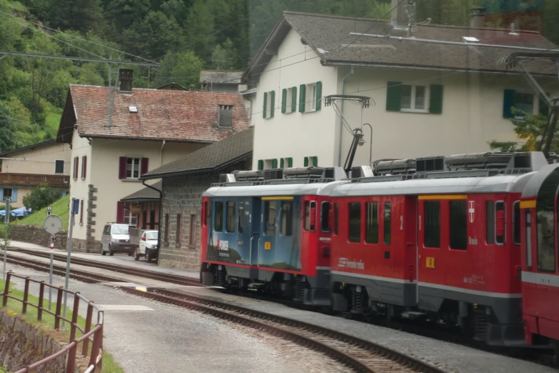 a train traveling past a white and red building