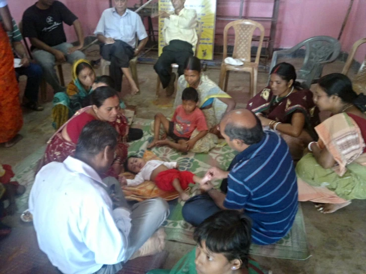 a group of people sitting around a baby