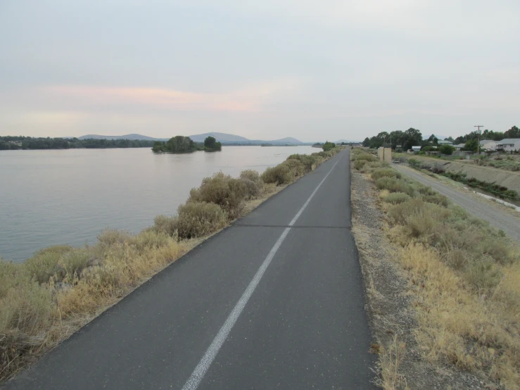 a motorcycle is parked next to the road near water