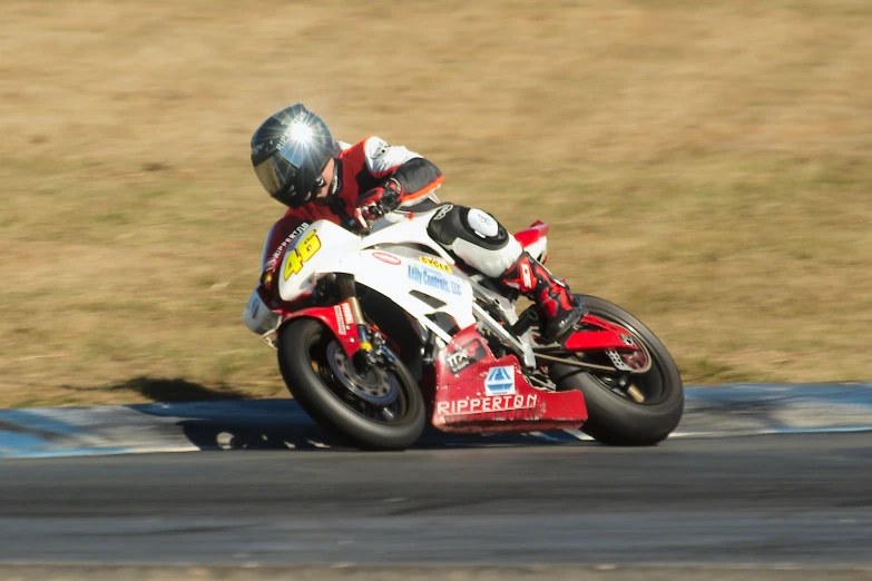 the man on a red and white motor bike is racing